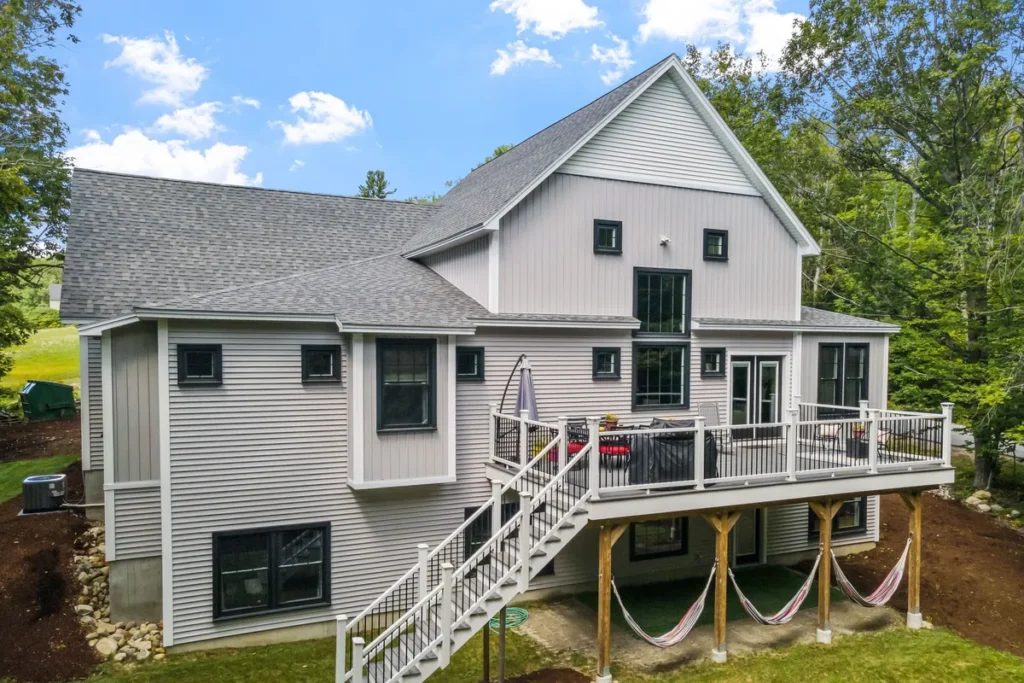 A modern New England colonial home with a beautiful garden, illustrating custom home design options.